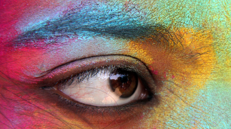 A student, with her face smeared in coloured powder, celebrates Holi, also known as the festival of colours, at a college in the northern Indian city of Chandigarh March 2, 2012.